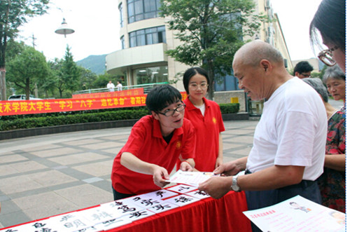 志愿者向居民讲解习总书记的“八字真经”